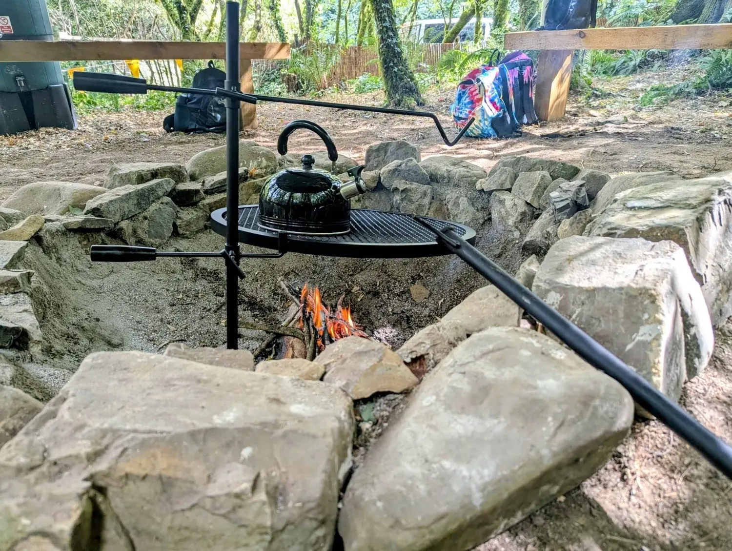 A kettle on a grill over the stone-built campfire circle A kettle on a grill over the stone-built campfire circle